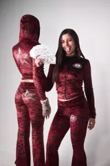 Conjunto de buzo y pantalón de terciopelo rojo con estampado animal print negro. El buzo es de corte ajustado, con capucha y cierre frontal. El pantalón es de corte acampanado y tiene un aplique de estrella de strass en la parte trasera.