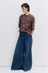 Remera de corte oversize color marrón con estampado tipo bandana en color blanco. Presenta cuello redondo y mangas cortas amplias.