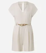 Enterito corto de mujer color beige claro, con escote en V, mangas cortas tipo capa, trabillas en la cintura y pliegues frontales. Incluye un cinturón fino trenzado de cuerda.