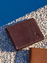 Billetera de cuero marrón con costuras reforzadas y logo de la marca grabado en la esquina inferior derecha.