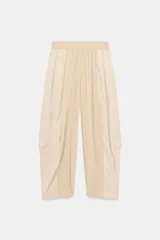 Pantalón de tiro medio con cintura elástica ajustable con cordón. Presenta un diseño de paneles laterales en tejido técnico contrastante y bolsillos tipo cargo. Su corte es holgado con pernera que se estrecha hacia el tobillo.