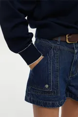 Short de denim azul medio con tiro medio, fit relajado y bolsillos utilitarios frontales.