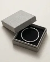 Pulsera esclava de acero compuesta por pequeñas esferas texturizadas con un diseño estriado.