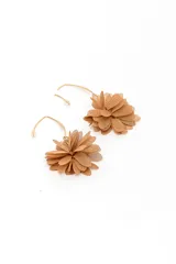 Caravanas colgantes de metal dorado con diseño de flor confeccionada en tela de malla beige.