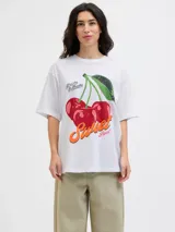 Remera de cuello redondo y mangas cortas, con calce holgado y estampa frontal de cerezas con texto decorativo.