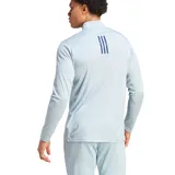 Remera de entrenamiento Adidas color celeste con cierre parcial y logo en el pecho.