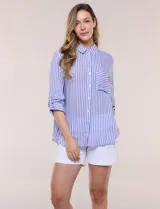 Camisa de corte clásico y silueta relajada con diseño de rayas verticales en azul y blanco, cuello camisero tradicional, cierre frontal con botones y bolsillo aplicado en el pecho con rayas horizontales. Cuenta con mangas largas con presillas para arremangar y ruedo redondeado.