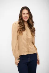 Blusa de color beige con textura acanalada, manga larga con puños ajustados y detalle de encaje vertical en el frente.