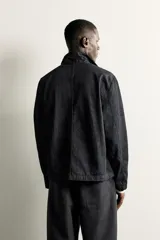 Sobrecamisa de corte relajado confeccionada en denim de algodón color azul oscuro. Presenta cuello solapa, manga larga, cierre frontal con botones y bolsillos plastrón en el delantero.