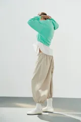 Pantalón de tiro medio y cintura elástica con cordón de ajuste, bolsillos laterales y bajo abullonado con puños elásticos. Confeccionado en poliamida.