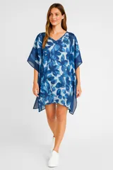 Túnica de corte holgado con cuello en V y mangas cortas tipo kimono. Presenta un estampado floral en tonos azules sobre fondo celeste.