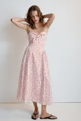 Vestido midi de popelina blanco con estampado de lunares rojos, escote corazón, tirantes finos con lazo y detalle de nudo en el busto.