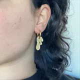 Par de aros colgantes plateados con forma de gota.