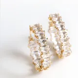 Aros tipo argolla dorados con incrustaciones de cristales blancos.
