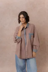 Camisa de denim color verde menta con calce relajado, cuello clásico, cierre frontal con broches metálicos, mangas largas y bolsillo aplicado en el pecho, con detalles en tono gris azulado a contraste en cuello, cartera, bolsillo y puños.