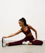 Pantalón jogger deportivo color bordó, con cintura elástica, bolsillos laterales y puños ajustados. Presenta recortes canelados en los laterales que aportan textura y diseño al modelo.
