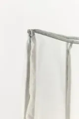 Falda midi semitransparente de tiro medio color gris, confeccionada en tejido satinado con aplicación de encaje en contraste en el bajo. Cuenta con cierre lateral con cremallera oculta.