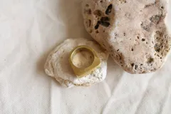 Anillo sello dorado de bronce con forma cuadrada.