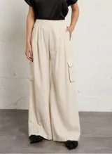 Pantalón ancho color beige a rayas con bolsillos cargo laterales y cintura elástica.