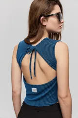 Top de textura acanalada y calce al cuerpo, sin mangas, con cuello redondo y diseño de espalda abierta con lazo para anudar.