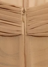 Vestido largo de gasa color tostado, con diseño recto y cuello halter cruzado con detalle drapeado. Presenta un diseño semitransparente con forro interior y cierre de cremallera en la parte posterior.