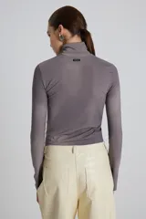 Polera gris de cuello alto, manga larga y corte ajustado.