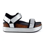 Sandalias plateadas con plataforma, tiras anchas de cuero sintético plateado con ajuste de velcro, base de corcho y suela de goma negra.