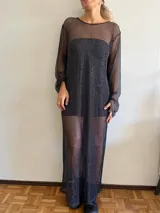 Vestido largo de red color negro con brillo plateado, de corte recto y mangas largas.