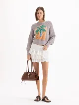 Cartera Kate de cuero vacuno diseñada para llevar al hombro, con cierre principal y bolsillo interno. Presenta aplique de candado y llavero tipo birkin en el frente, además de tiras laterales decorativas.