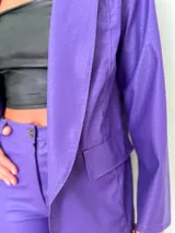 Blazer lila con textura croco, solapas amplias y bolsillos frontales.