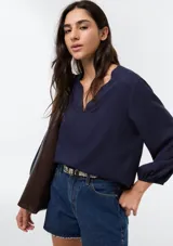 Blusa de viscosa color azul marino, con escote en V y mangas tres cuartos con puños elásticos.