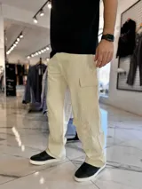 Pantalón cargo de jean oversize en color beige, con bolsillos laterales en las piernas y corte holgado.