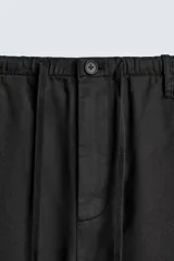 Pantalón de corte regular fit confeccionado en mezcla de algodón y lino. Presenta cintura elástica con cordón ajustable, cierre frontal con cremallera y botón, bolsillos laterales y bolsillo trasero de vivo con botón.