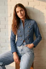 Chaqueta de estilo militar color marrón, con cuello mao y cierre frontal de doble botonadura con botones metálicos dorados.