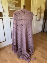 Ruana tejida a mano en lana merino 100%, color verde militar, con diseño de puntos calados y flecos largos en el ruedo.