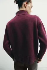 Jersey de punto liso con cuello subido, manga larga y acabados en rib en puños, cuello y ruedo.