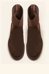 Bota tipo chelsea de gamuza color marrón, con paneles laterales elásticos acanalados y suela de goma track con taco bajo.