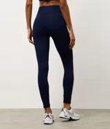 Legging deportiva de tiro alto en color azul marino, con franjas laterales en contraste de color bordó y beige. Confeccionada en microfibra elástica, ofrece un ajuste ceñido y cómodo para actividades físicas.