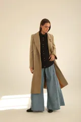 Tapado largo de paño en color beige, con solapas clásicas, cierre frontal de dos botones y corte recto estructurado.