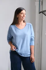 Remera de algodón color celeste, con cuello redondo, mangas largas y diseño holgado con costuras visibles.