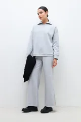 Pantalón gris melange de corte ancho, con tajos laterales en el ruedo.