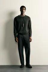 Pantalón regular fit de hombre color negro, confeccionado en tejido técnico ligero con cintura elástica, bolsillos frontales, bolsillos traseros de vivo y cierre frontal con cremallera y botón.