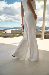 Pantalón de lino color blanco, de tiro alto y corte oxford con perneras amplias. Cuenta con cintura elastizada y bolsillos laterales.