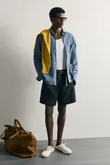 Bermuda regular fit azul marino confeccionada en lino, con bolsillos frontales, bolsillos traseros de doble vivo con botón y cierre frontal con cremallera y botón.