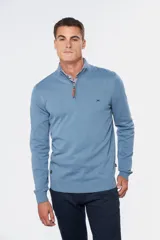 Buzo liso de punto fino en hilo de algodón color azul marino, con cuello alto y cierre frontal parcial con detalle de tirador de cuero.