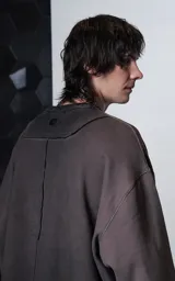 Buzo de cuello redondo con efecto de lavado maltinto o nevado. Presenta un corte oversize con hombros caídos, costuras expuestas a contratono y detalles de roturas desgastadas en el cuello, puños y ruedo.