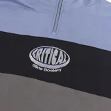 Buzo canguro con medio cierre de felpa cepillada, diseño de bloques de color en tonos celeste, negro y gris oscuro, con logo impreso en el pecho y calce oversize.