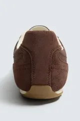 Zapatilla de estilo retro con cordones, confeccionada en una combinación de piezas de tela y cuero con acabado de gamuza. Cuenta con suela dentada en contraste.