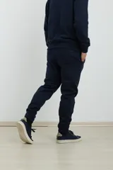 Pantalón jogging de corte ajustado, con cintura elástica y puños elastizados en los tobillos. Presenta un diseño minimalista en color gris oscuro, ideal para un look urbano y deportivo.