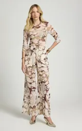 Pantalón de tul Le Lis Blanc modelo Marfim, de pierna ancha y corte fluido, con estampado abstracto en tonos beige y marrón. Cuenta con cinturilla drapeada en la parte delantera y forro interior corto.